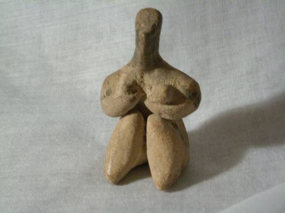Ancient terra cotta figure of a fertility sybol from Sumer.  It is a styalized image of a young woman.  